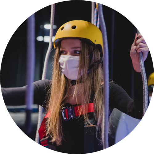 woman in a ropes course helmet smiling.